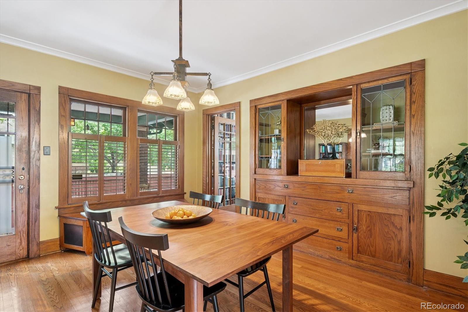 2201 Cherry Street Denver, CO 80207 - Photo 11 of 46 a dining room with furniture a chandelier and wooden floor