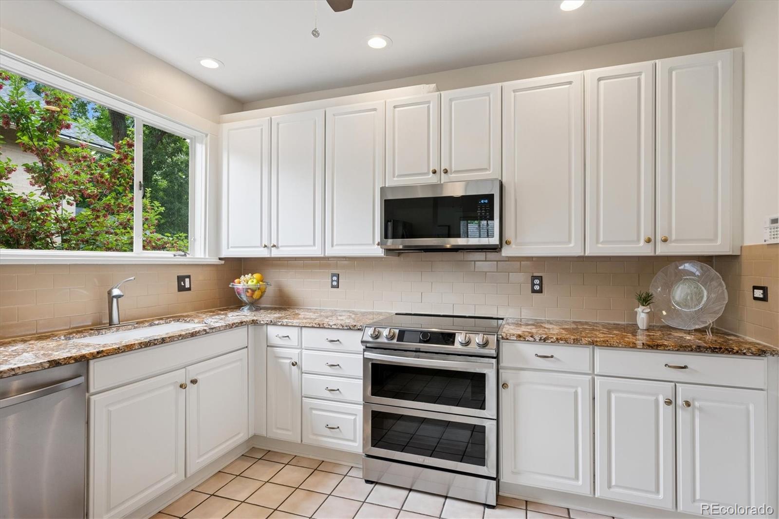 2201 Cherry Street Denver, CO 80207 - Photo 16 of 46 a kitchen with granite countertop white cabinets and appliances