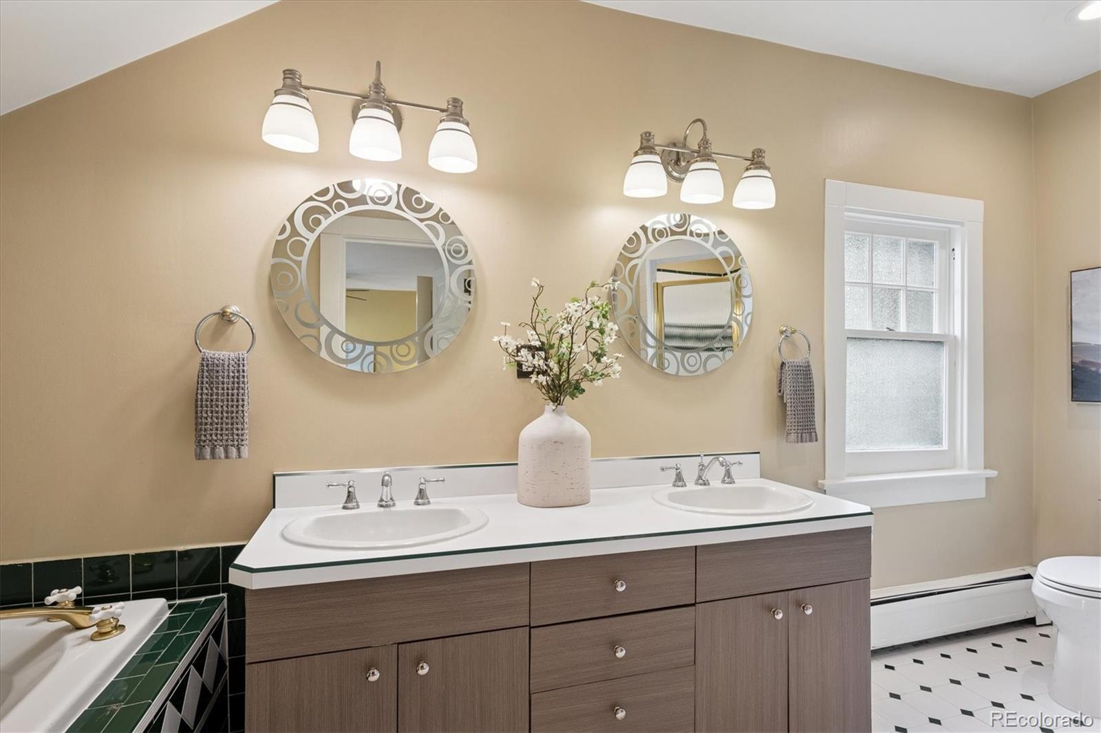2201 Cherry Street Denver, CO 80207 - Photo 22 of 46 a bathroom with a double vanity sink and a mirror