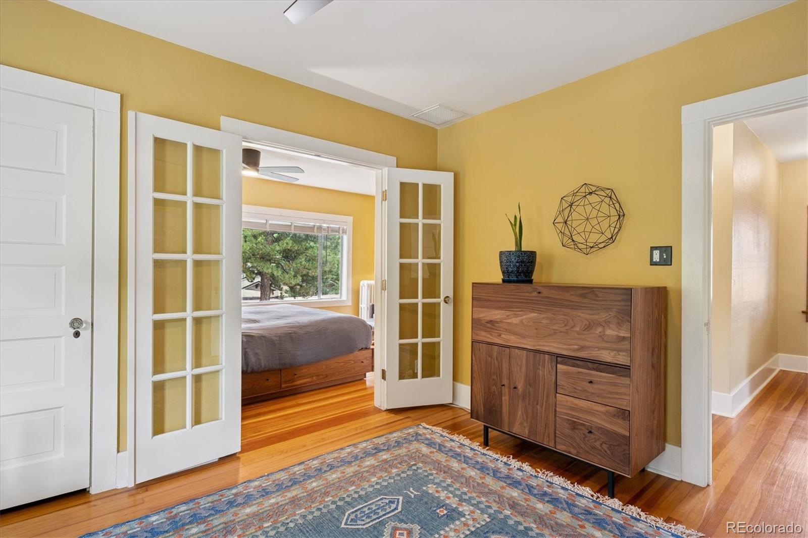 2201 Cherry Street Denver, CO 80207 - Photo 23 of 46 a bedroom with a bed and wooden floor