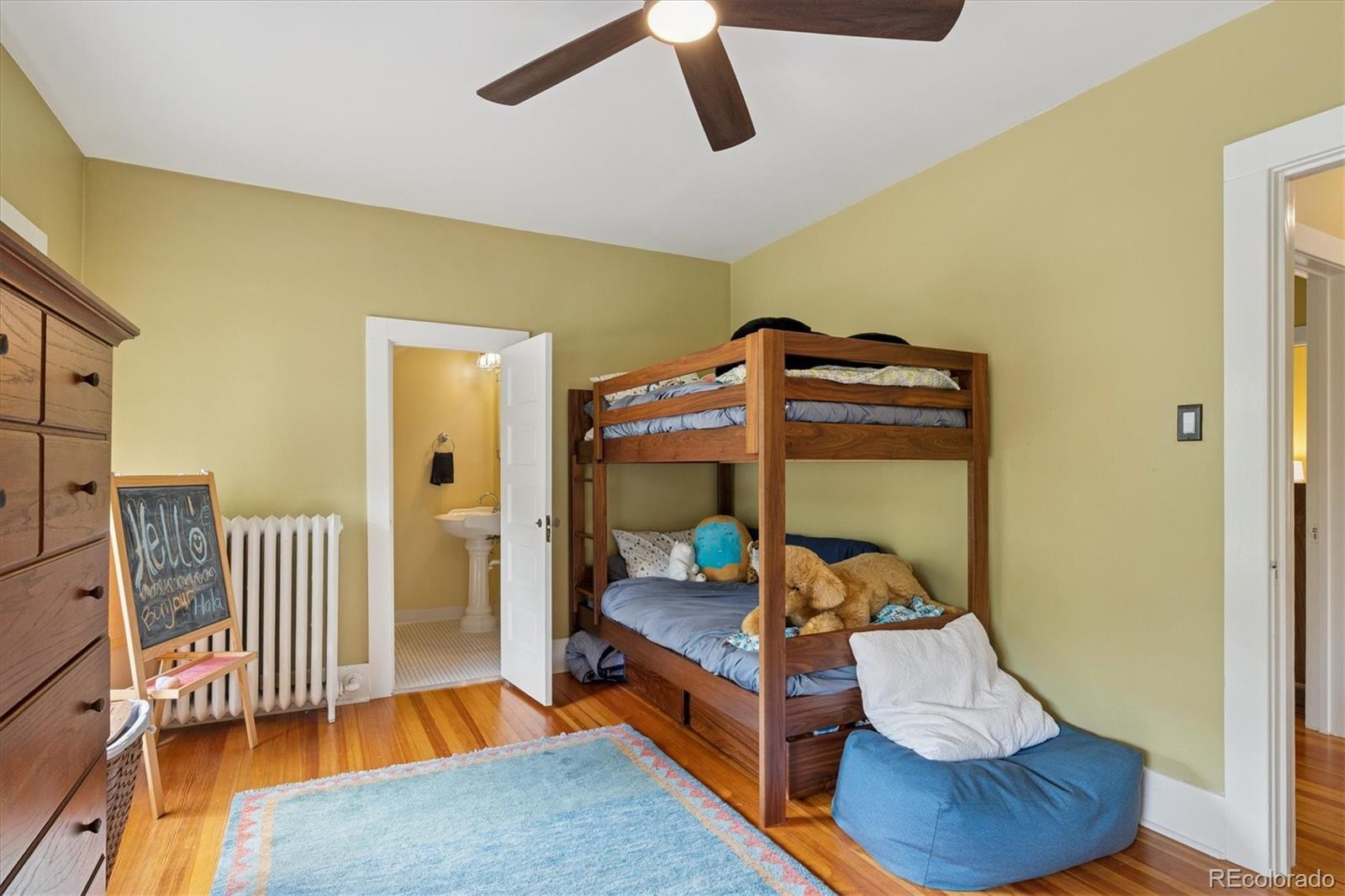 2201 Cherry Street Denver, CO 80207 - Photo 26 of 46 a bedroom with a bed and wooden floor