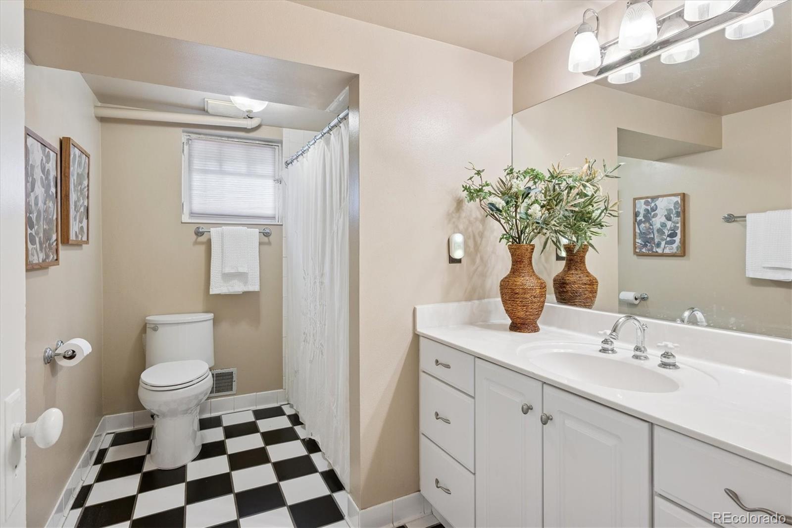 2201 Cherry Street Denver, CO 80207 - Photo 33 of 46 a bathroom with a sink a toilet and a mirror