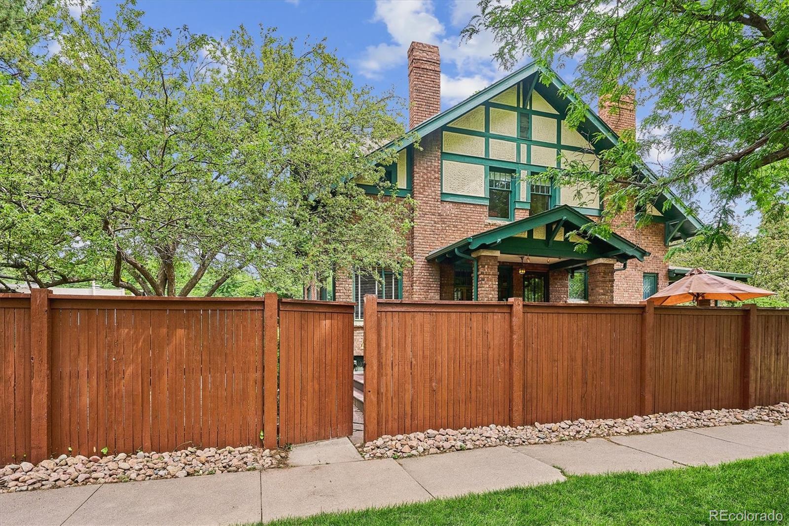 2201 Cherry Street Denver, CO 80207 - Photo 39 of 46 a front view of a house with a yard and wooden fence