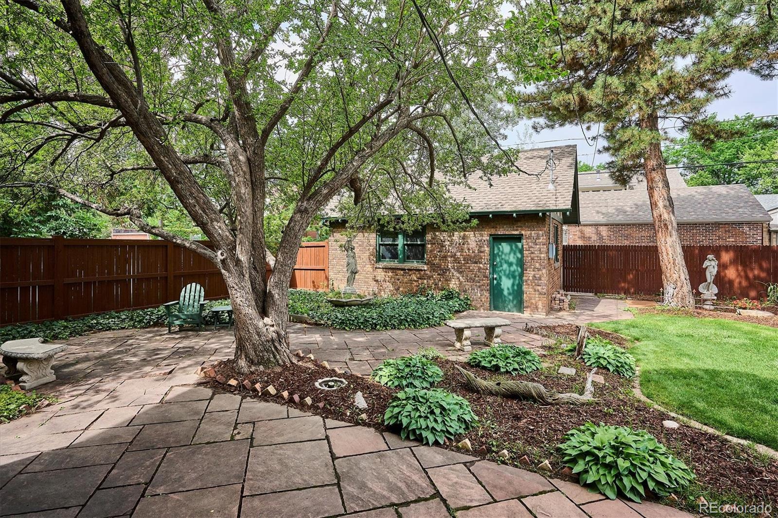2201 Cherry Street Denver, CO 80207 - Photo 44 of 46 a front view of a house with a yard and a tree
