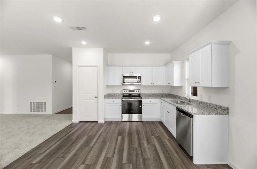 10308 Holy Cross Lane Crowley, TX 76036 - Photo 15 of 27 a large kitchen with a white stove top oven and white cabinets