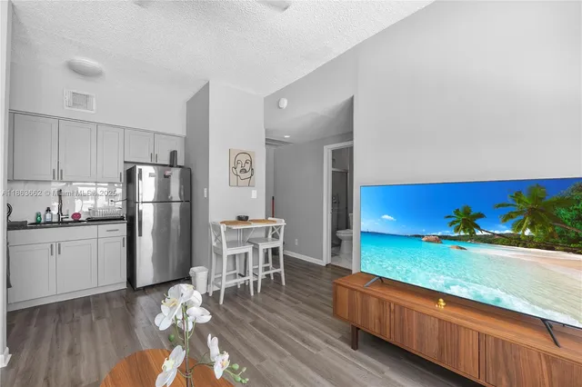 a kitchen with stainless steel appliances granite countertop a refrigerator a stove and a wooden floors