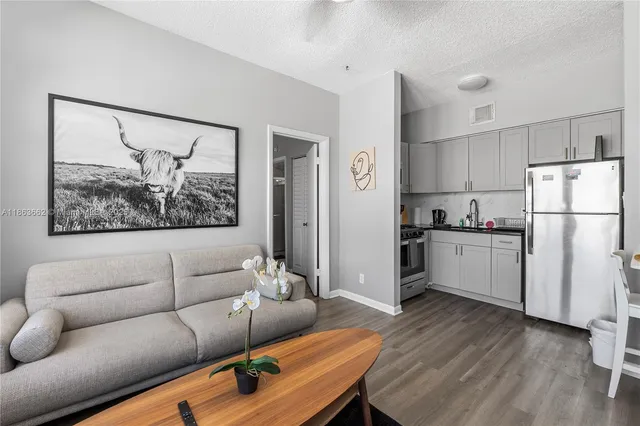 a living room with furniture and a refrigerator