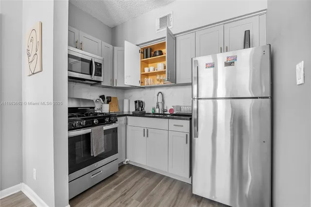 a white refrigerator freezer and a stove sitting inside of a kitchen