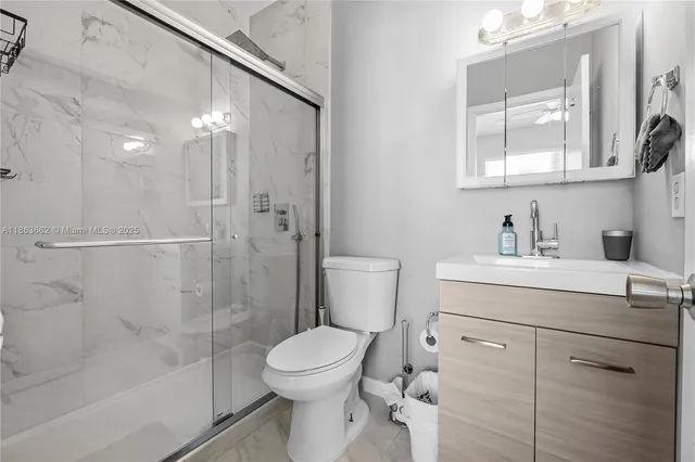 a bathroom with a sink a mirror a toilet and shower