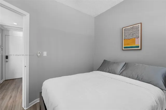 a bedroom with a bed and painting on the wall