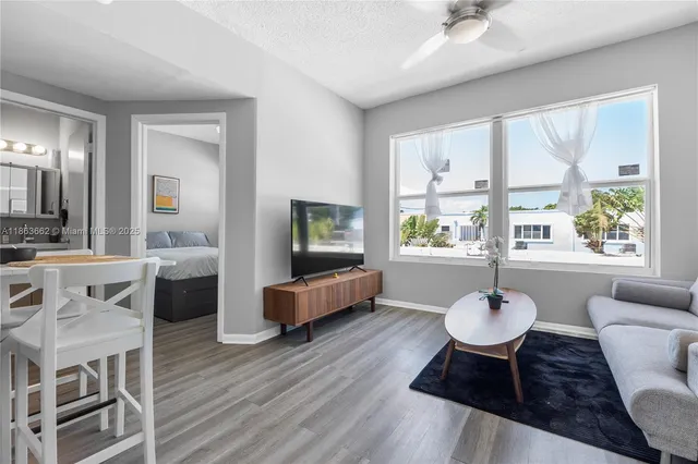 a living room with furniture a flat screen tv and a large window