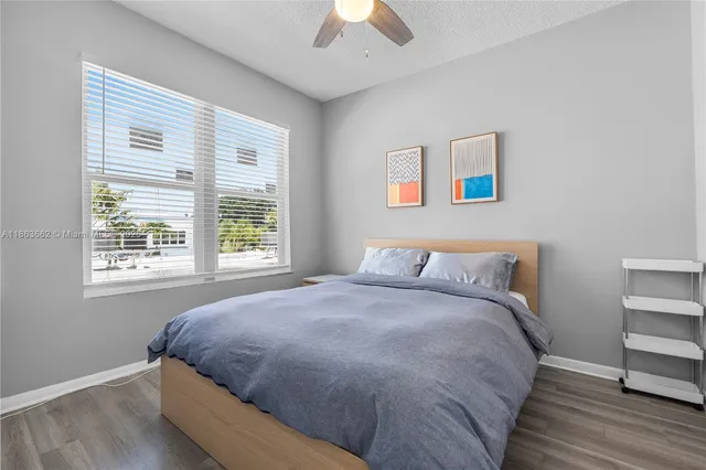 a large bed sitting in a bedroom next to a window and a chandelier