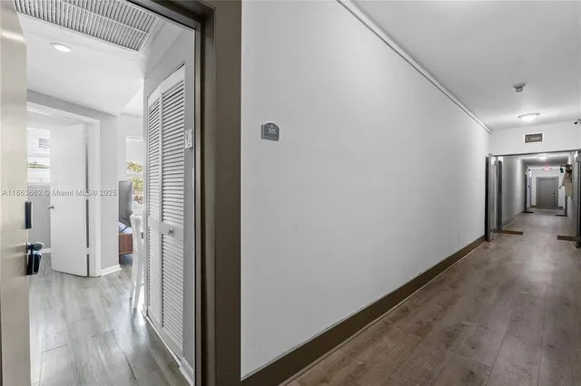 a view of a hallway with wooden floor and stairs