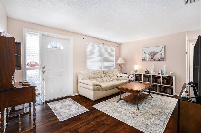 a living room with furniture and wooden floor