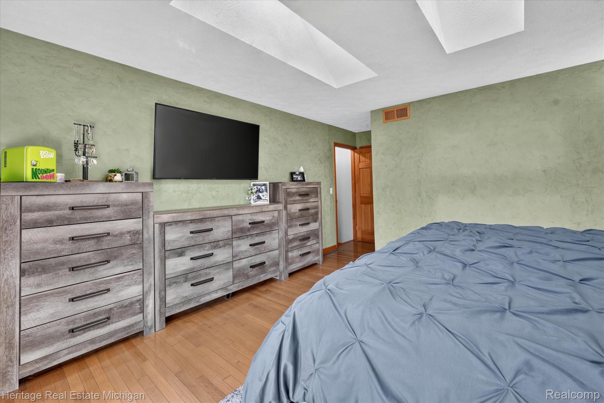 1888 Germany Road Williamston, MI 48895 - Photo 20 of 57 Spacious primary bedroom with sloped ceiling and skylight flooding the space with natural light