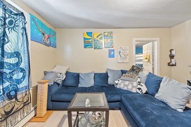 a living room with furniture and painting on the wall