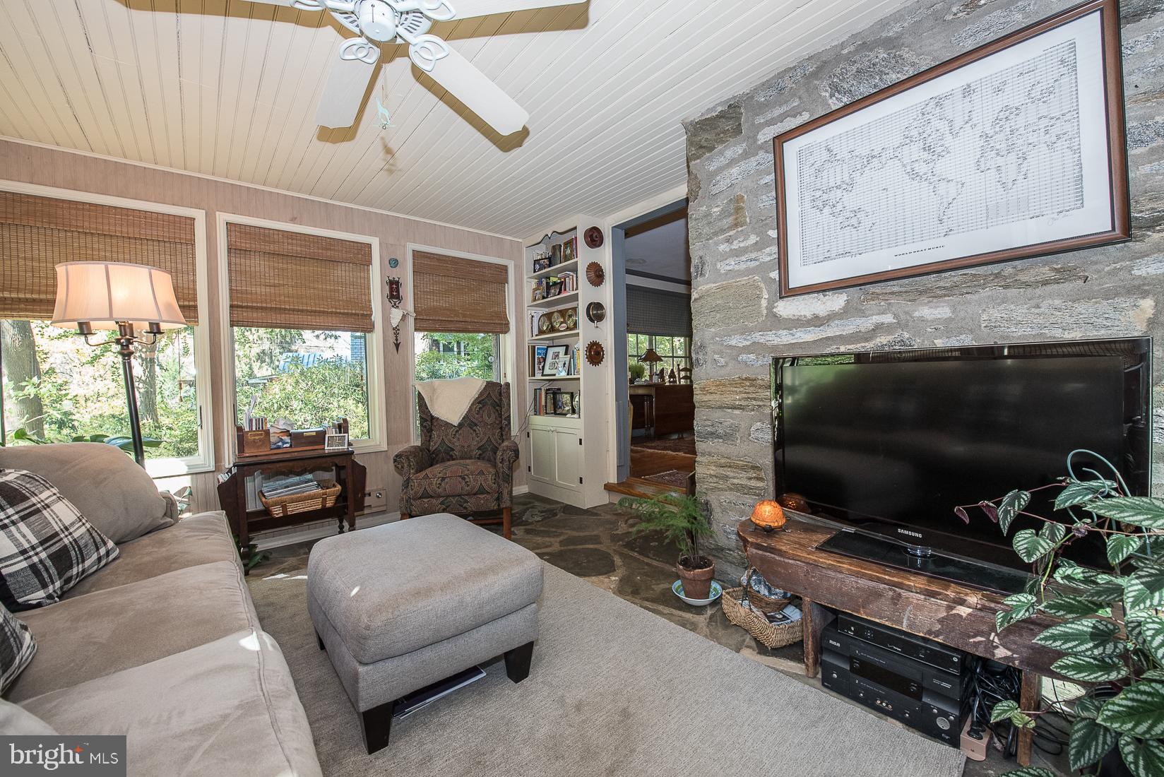 35 South Providence Road Wallingford, PA 19086 - Photo 14 of 71 a living room with furniture a flat screen tv and a floor to ceiling window