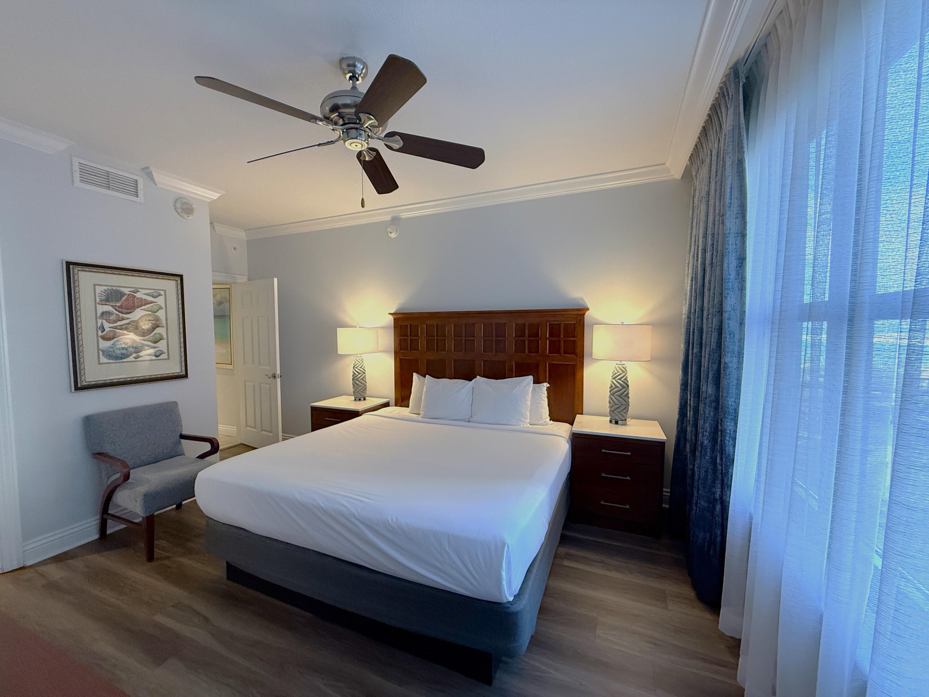 10 Harbor Boulevard, Unit E802B Destin, FL 32541 - Photo 7 of 25 a bedroom with a bed and wooden floor