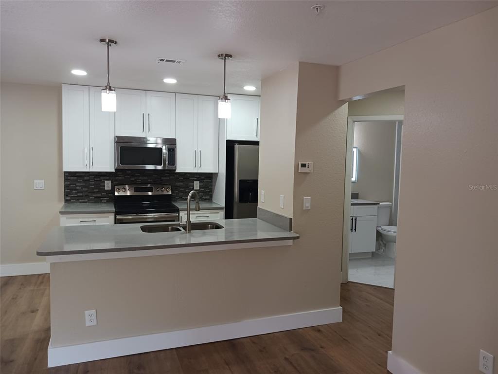 623 Dory Lane, Unit 306 Altamonte Springs, FL 32714 - Photo 11 of 21 a kitchen with stainless steel appliances a sink stove and refrigerator