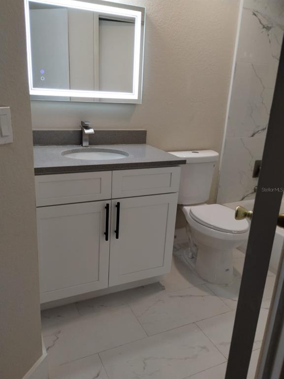 623 Dory Lane, Unit 306 Altamonte Springs, FL 32714 - Photo 20 of 21 a bathroom with a granite countertop toilet sink and mirror