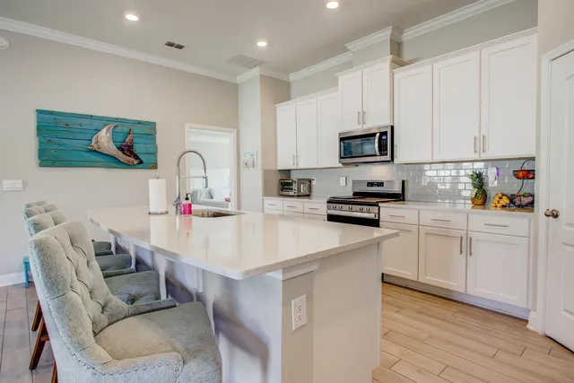 a kitchen with stainless steel appliances granite countertop white cabinets sink and stove
