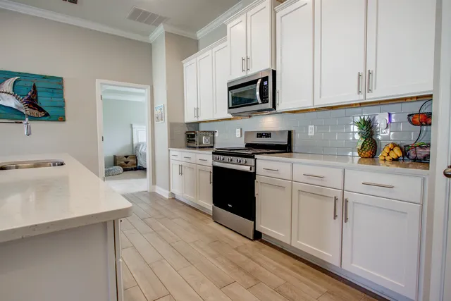 a kitchen with white cabinets and appliances