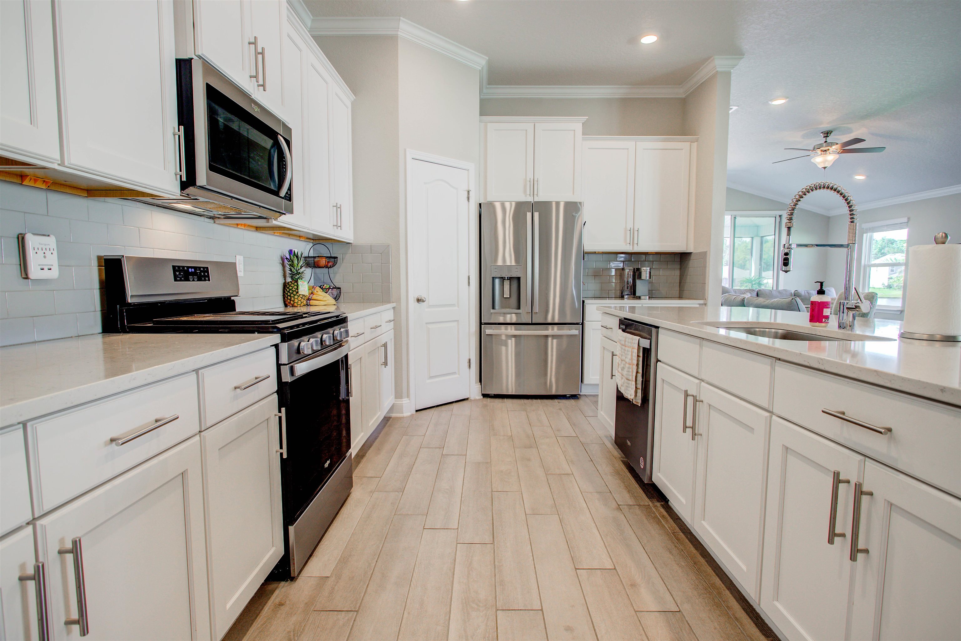 130 Huesca Court St. Augustine, FL 32084 - Photo 17 of 63 Kitchen with appliances with stainless steel finishes, ornamental molding, white cabinets, decorative backsplash, and ceiling fan