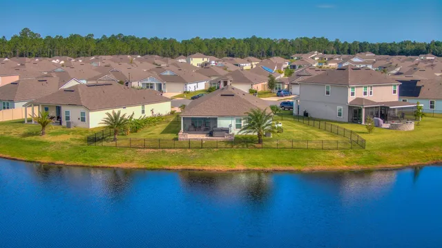 an aerial view of residential houses with outdoor space and swimming pool