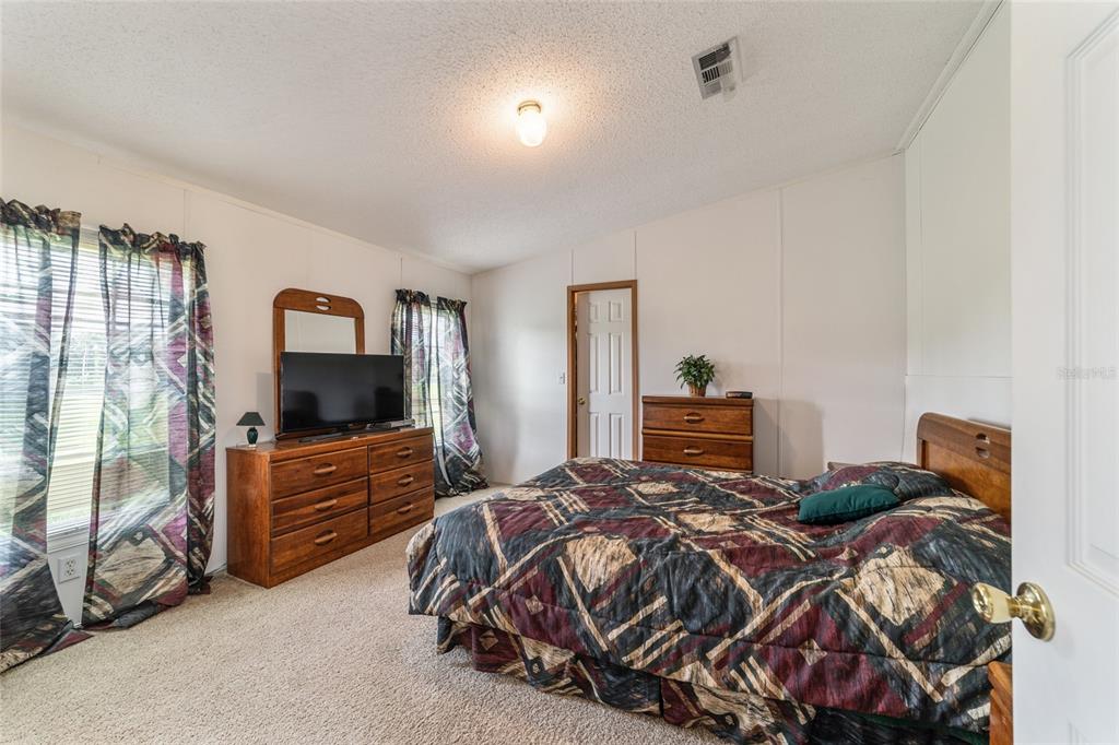 17176 North US Highway 441 Reddick, FL 32686 - Photo 25 of 42 a bedroom with a bed and flat tv screen on the dresser