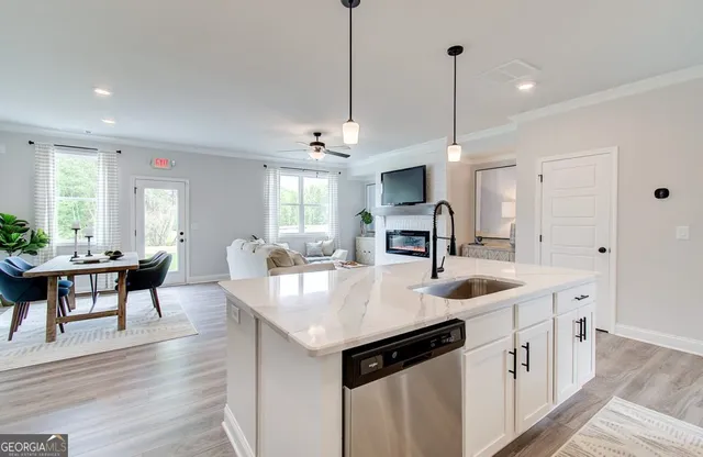 a kitchen with stainless steel appliances granite countertop a sink a stove and a wooden floor
