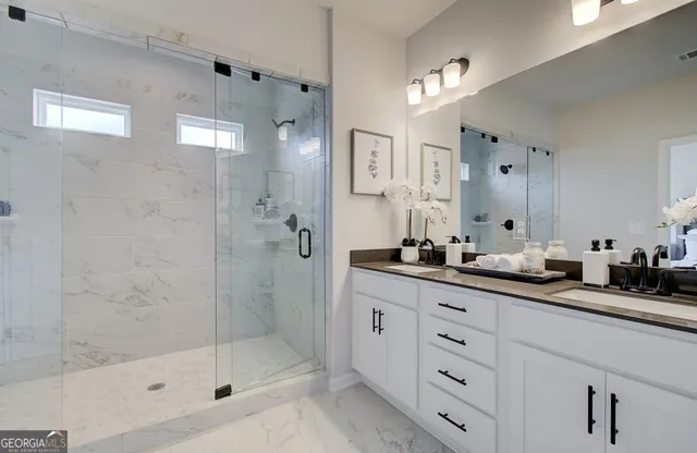 a bathroom with a double vanity sink a large mirror a shower and a bathtub
