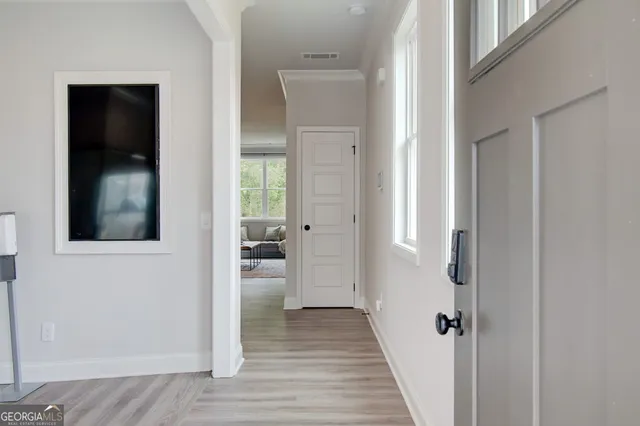 a view of a hallway with wooden floor and a living room