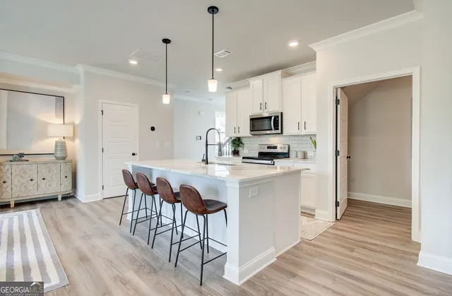 a kitchen with kitchen island granite countertop a sink cabinets and wooden floor