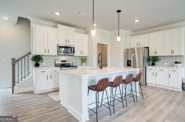 a kitchen with white cabinets and stainless steel appliances