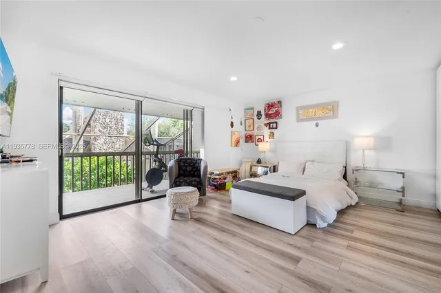 a spacious bedroom with a bed and wooden floor