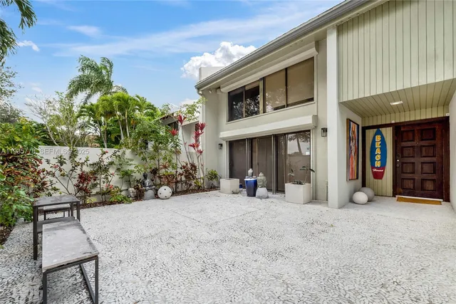 a view of a house with potted plants in front of door