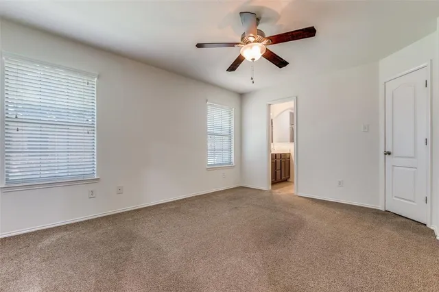 an empty room with a ceiling fan and a window
