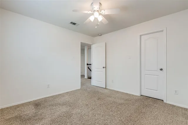 a view of an empty room and a ceiling fan window