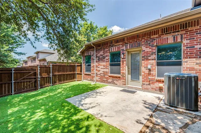 a view of a backyard with wooden fence and a large tree