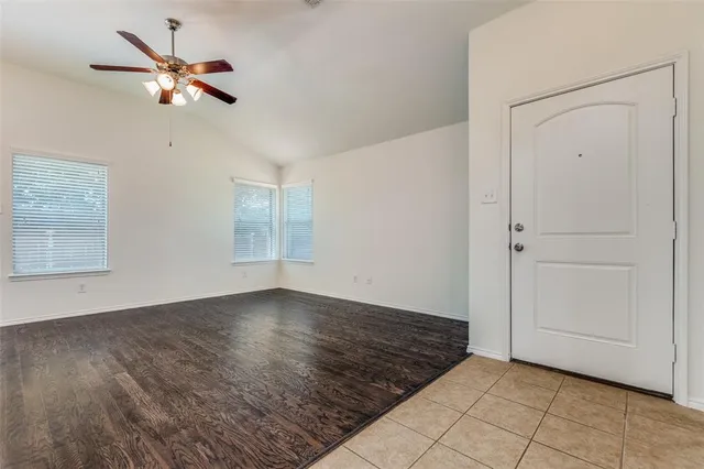 an empty room with fan and windows