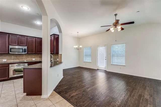 a kitchen with stainless steel appliances granite countertop a refrigerator a sink and a stove