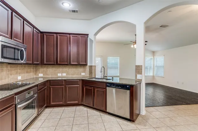a kitchen with a sink stove top oven and cabinets