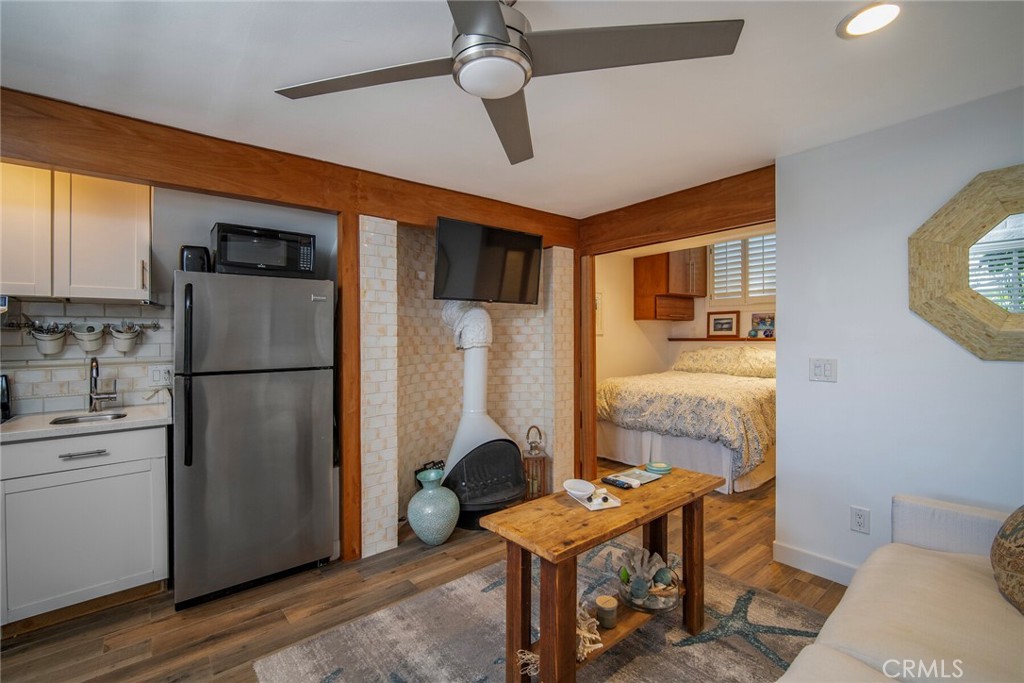 33915 Robles Drive, Unit B Dana Point, CA 92629 - Photo 6 of 22 a kitchen with stainless steel appliances granite countertop a refrigerator a sink a stove a dining table and chairs with wooden floor