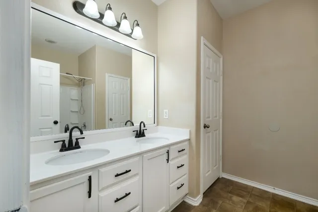 a bathroom with a double vanity sink and a mirror