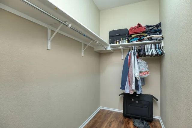a view of walk in closet with clothes and shoes