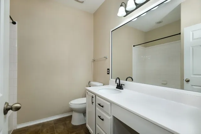 a bathroom with a double vanity sink toilet and a mirror