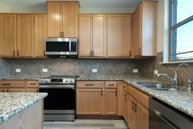 a kitchen with stainless steel appliances granite countertop a sink stove and microwave