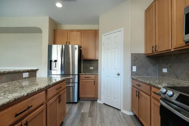 a kitchen with stainless steel appliances granite countertop a refrigerator and a stove