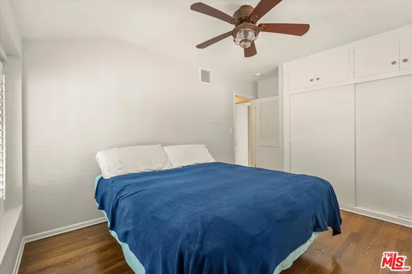 a bedroom with a bed and a ceiling fan