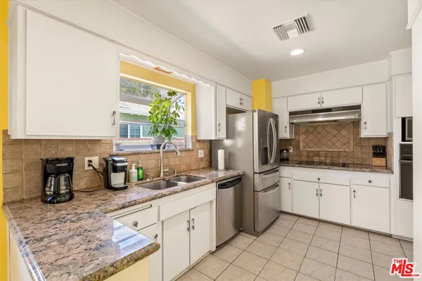a kitchen with granite countertop a sink stainless steel appliances and cabinets